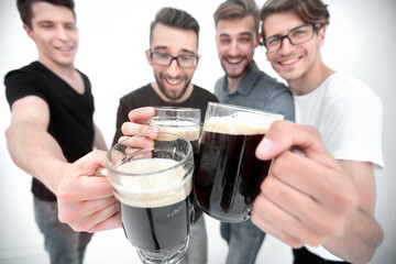 close up.mugs of beer in the hands of a group of men
