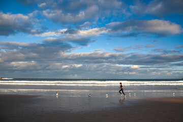 an Australian surfer is running on Bondi beach, sydney