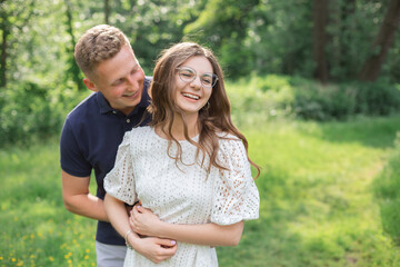 Romantic moments of happy european couple in love enjoying vacation in park. Hugging and having fun together. 