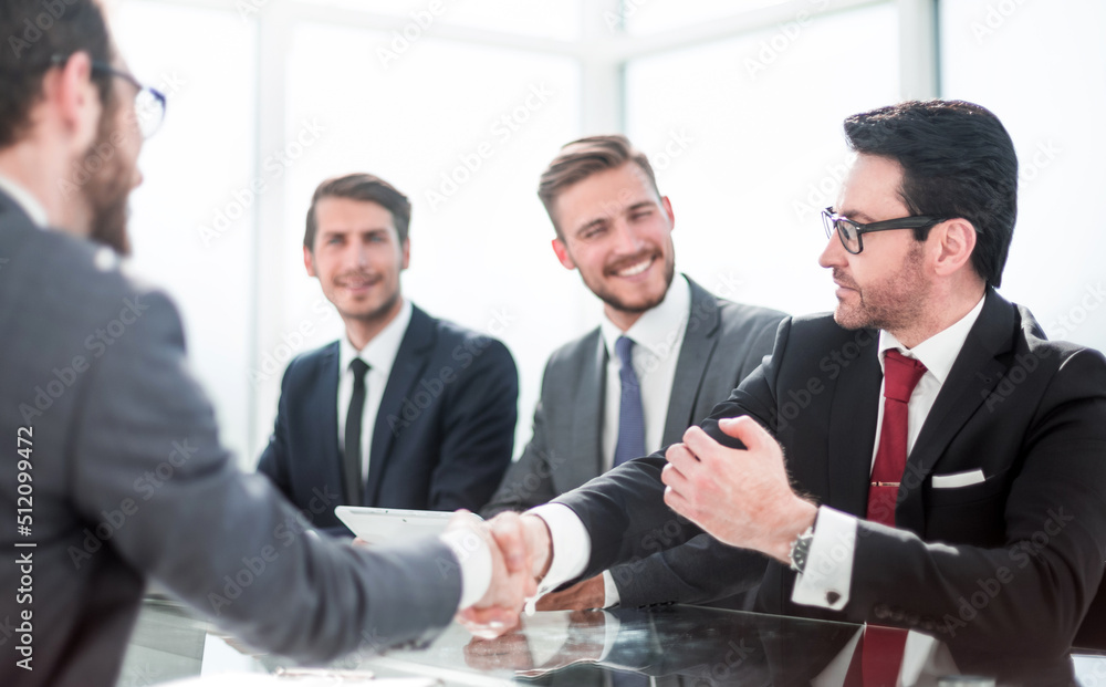 Wall mural business hands shaking hands sitting at the office Des