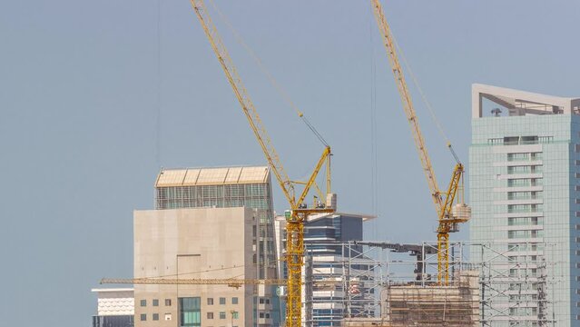 Cranes working on constraction site with new skyscrapers on a background timelapse. Urban development of high-rise towers and building activity at the big city