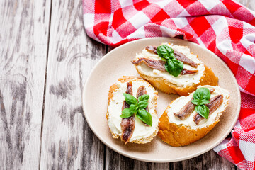 sandwich with anchovy fillet on a tray for serving on a wooden rustic background
