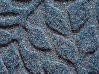 Textured wool or felt background with convex patterns. Macro photo of the surface of the doormat