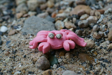 A toy crab made of plasticine on the river bank. Hobbies and recreation.
