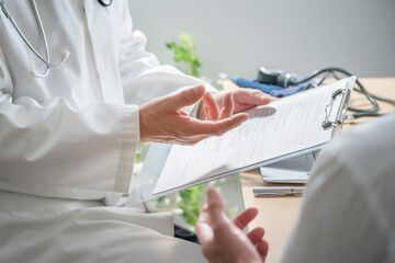 Doctor and patient taking notes or questionnaire in medical surgery