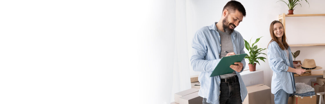 casual couple checking things to do on clipboard, woman and man working in team while making relocation issues together and taking notes. banner - Powered by Adobe