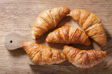 fresh croissants on wooden board