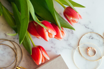Beautiful tulips, notepad, pen and other women's fashion accessories on the table