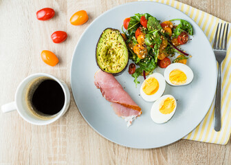 Plate with a keto diet food. Eggs, vegetable salad with tomatoes, bacon, avocado and cup of coffee. Keto breakfast.  Long banner format