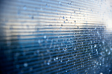 Raindrops on the glass blue polycarbonate surface