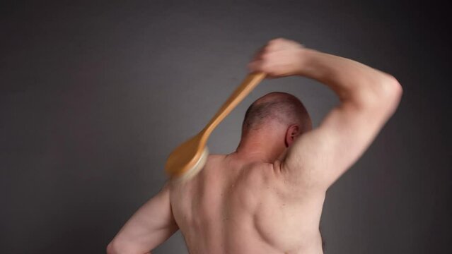 senior man is practicing dry brushing for skin detoxification, promoting lymph flow and stimulating nervous system, self care concept