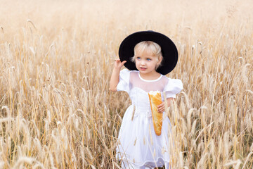 Happy three years old girl smiling and laughing in summer day at nature. Portrait of handsome blond girl with blue eyes, face close up at summer time, in the wheat field.