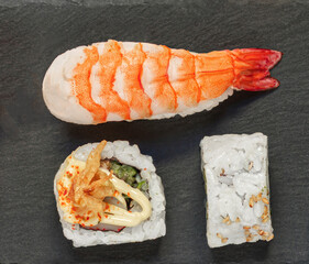 Sushi rolls set an a black slate  background. Japan restaurant menu. Sushi with salmon, tuna and avocado. Top view. Flat lay