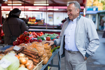 Middle aged man buying vegetables