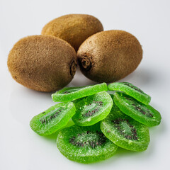 green dried kiwi on a white acrylic background