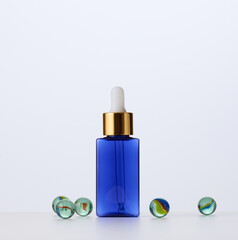 blue glass bottle with pipette for cosmetics, oils and serum. Advertising and product promotion