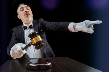 Auctioneer, salesperson with gavel at public auction. Senior male barker in formal elegant suit with auction hammer for close the bidding