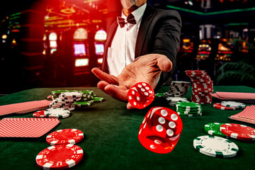 Gambling concept. Close up of male hand throwing dice at casino, gambling club. Сasino chips or...