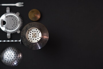 Old cocktail shaker and bartender tools onblack background with copy space, space for logo,...