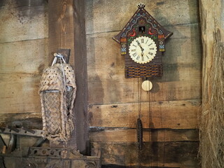 Old clock on a wooden light wall. Vintage clock. Cuckoo clock. Copy-space.