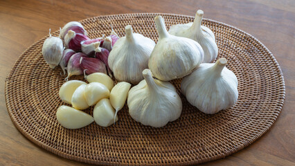 アタに置かれたにんにく（ニンニク、大蒜、ガーリック）丸とバラとむき