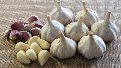 和風マットに置かれたにんにく（ニンニク、大蒜、ガーリック）丸とバラとむき