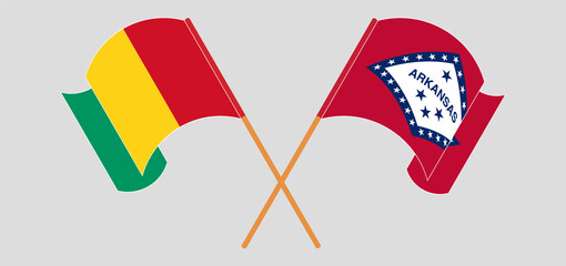 Crossed and waving flags of Guinea and The State of Arkansas
