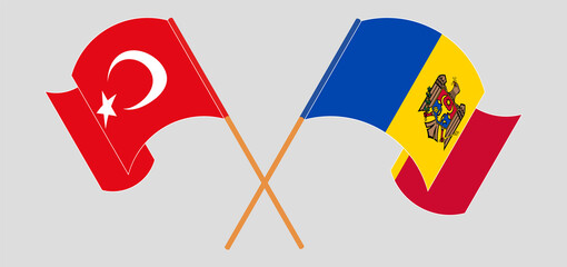 Crossed and waving flags of Turkiye and Moldova