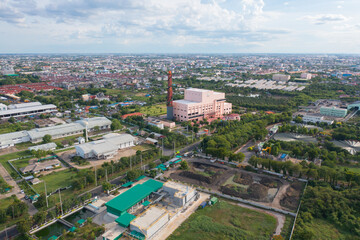 Aerial view of stack of different types of large garbage pile, plastic bags, and trash with a tractor car in industrial factory in environmental pollution. Waste disposal in dumping site.
