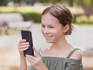 Foto op Canvas Gelukkig meisje praten op haar telefoon. Mooi kind dat op internet surft © Albert Ziganshin