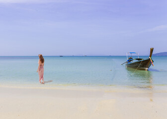 Fototapeta na wymiar woman walking on the sea on sunny day with blue sea background