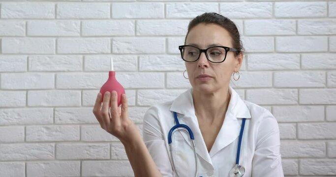 Start medical procedure. A woman in medical coat think abou procedure with enema in the room.