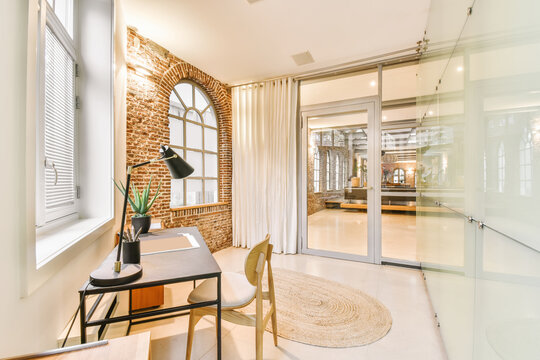 Stylish workroom with table at wall
