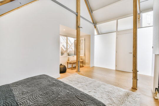 Interior of attic room with cozy bed and wood beams