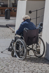 Obraz premium A disabled person sitting in a wheelchair on Torun street