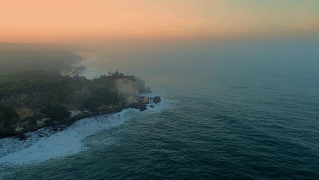 Beautiful rock beach aerial footage foggy sunrise horizon