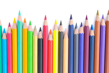 Lots of colored pencils lined upisolated on white background.