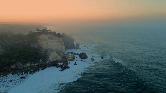 Rock beach aerial footage foggy sunrise