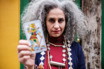 Psychic mature woman reader showing us an out of focus tarot card.