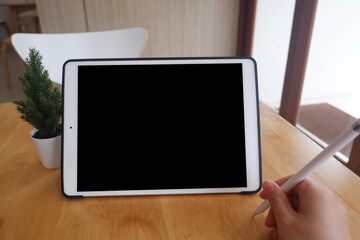 Mockup picture of business woman’s hands using tablet with white blank screen in modern place