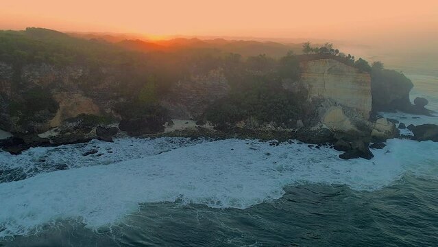 Cinematic aerial footage of rock beach sunrise in golden hours