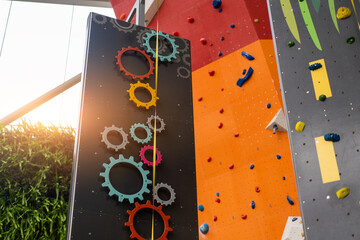 Indoor bouldering and climbing wall for training at modern gym. Gears and toy climbing wall for children
