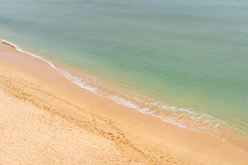 Fototapeta na wymiar Aerial view of sea waves and sandy beach