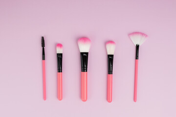 makeup brushes on pink background