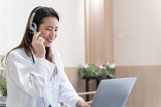 telemedicine concept, Asian woman doctor in headset taking calling on her headset microphone online for a ache patient