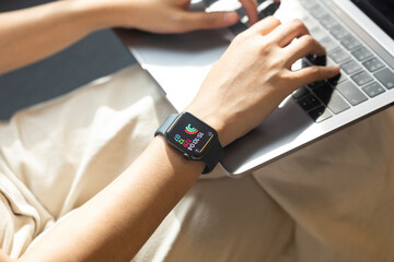 Close-up of the hands of a woman working from home with laptop and a smartwach.