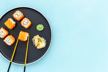 Japanese cuisine. Salmon sushi rolls set on plate, top view
