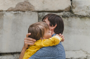 man dad having quality time with their kid son boy six year old hug on arms. happy father playing together with child. real life authentic day-to-day fatherhood moments. fatherly love care affection