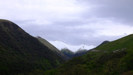 Mountain snow caps under grey sky