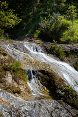 Fototapeta na wymiar Kleiner Wasserfall über Steinwand in der Weißbachschlucht